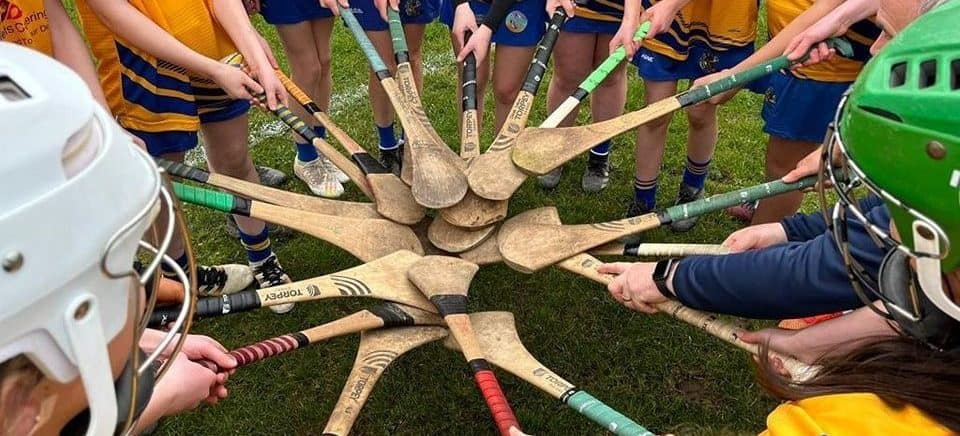 A camogie team members touch their hurls together